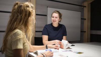 Two female Falmouth University students sat at a table with open books