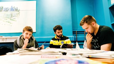 Three Journalism and Creative Writing students studying at a table