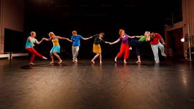 Dance students dressed in colourful clothes in a line