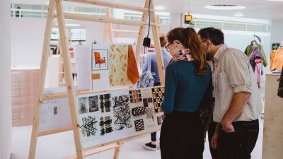 A father and daughter looking at an art exhibition at Falmouth University