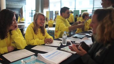 Falmouth ambassadors in their yellow sweatshirts talking to guests at Open day.