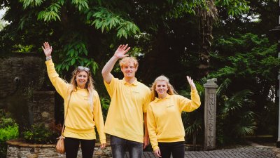 Three Falmouth University Ambassadors waving