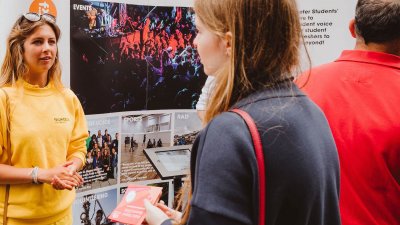 A Falmouth University student ambassador talking to a girl wearing a navy jacket