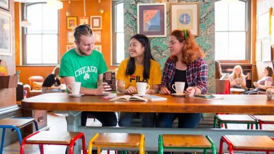 Brightly dressed Falmouth students having coffee in brightly decorated cafe.