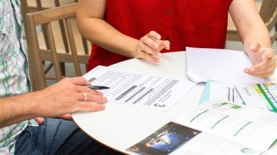 Hands on a white table with a range of documents