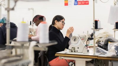 Student at a sewing machine in Fashion Design studio at Falmouth University 