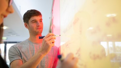 Falmouth University business student writing on a white board