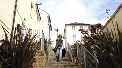 Student walking down steps between buildings.