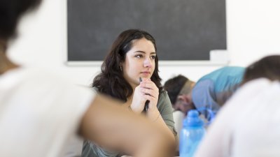 Student resting chin on her hands in lecture.