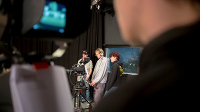 Close up of person operating a film camera in a film studio