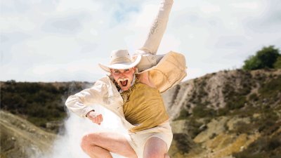 A person dressed as a cowboy jumping in the air in a disused Cornish mine