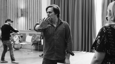 A male performer teaching a class looking away from the camera with his hand held out