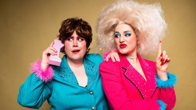 Two brightly coloured dressed people posing for the camera