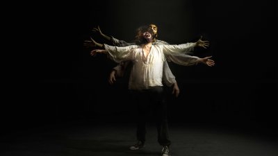 A person in the centre of the image with their arms spread out widely screaming