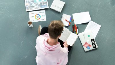 Student sitting on floor working on a project 