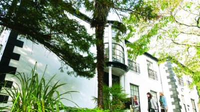 A white building behind greenery
