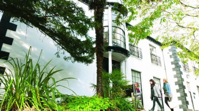 A white building behind greenery