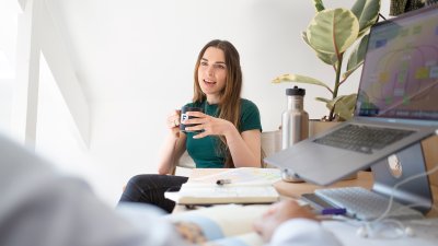 Person sat at table next to laptop talking