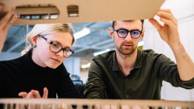 Interior design students looking at cardboard model