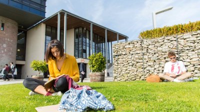 Students sit and read on the grass outside the Stannary