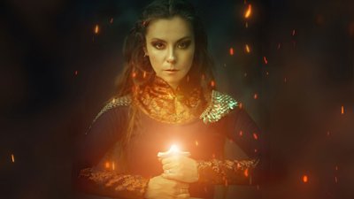 A celtic women looking at the camera holding a glowing sword