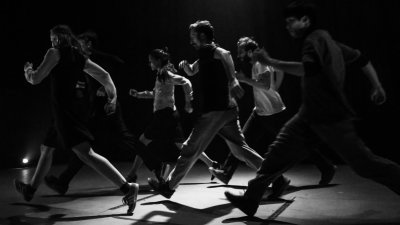 A black and white image of people dancing on stage