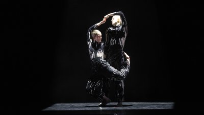 @ dancers dressed in black and silver performing on stage