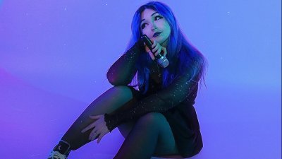 A person sat on the floor with a deep purple light on them