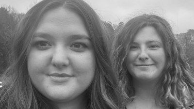 A black and white image of two people outside