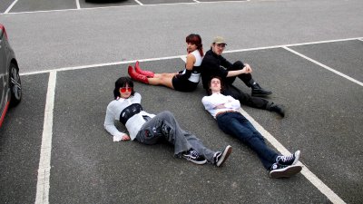A group of people laying down in a car park