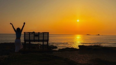 A sunny image with a person next to a bench