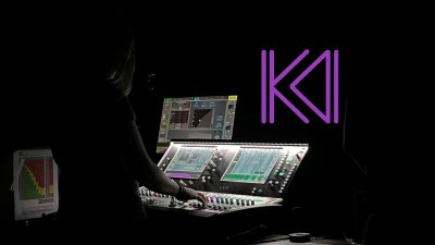 A person mixing a live band with a mixing desk in view