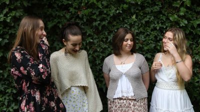 Four singers in a line against a green tree