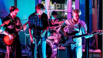 A brightly coloured image of 4 musicians performing at a local gig