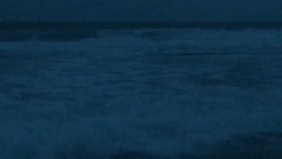 A dark image of waves with the text "Surveil" split across the top and bottom of the image