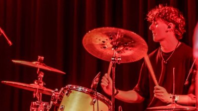 A person drumming under a orange red light