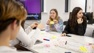 Group of students sat round a table mind mapping 