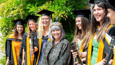 Chancellor Dawn French with female students at Falmouth University graduation ceremony