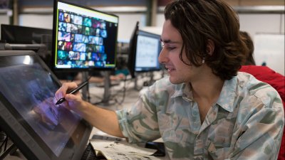A male Game Art student from Falmouth University drawing on a digital screen