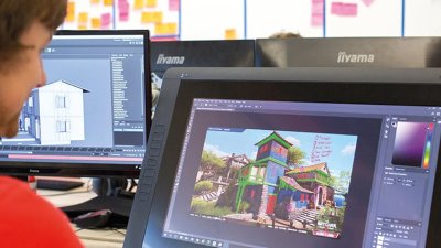 Someone sat at a laptop working on a game programme