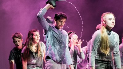Theatre students on stage pouring water on head