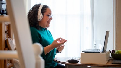 Woman sat at laptop laughing