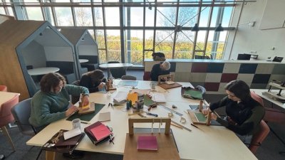 Group of people bookbinding at a table