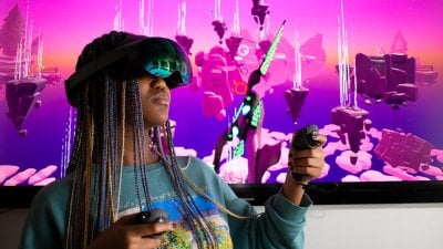 Falmouth University student wearing a VR headset in front of a pink screen