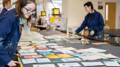 Photo of people working on textiles in a studio