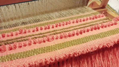 Weaving a wall hanging in progress on a table loom