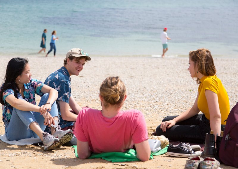 Falmouth University students relaxing on the beach