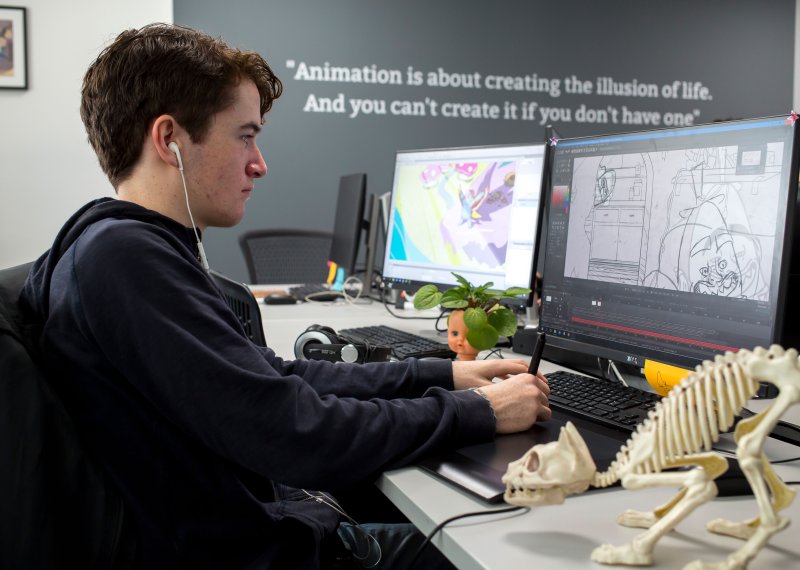 Animation students working at computer and drawing with a tablet