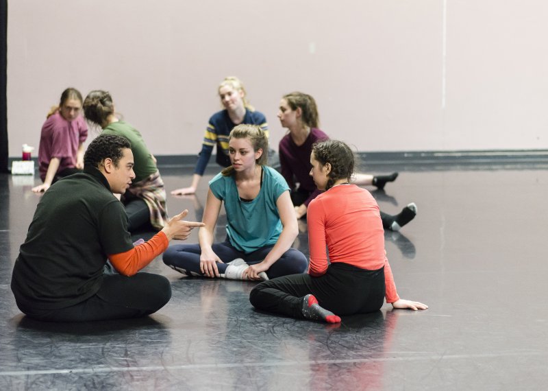 Group of theatre students sat on floor and discussing.