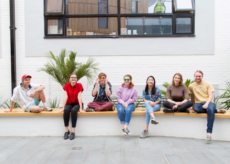 Student smiling and sitting on wall in Fox cafe.